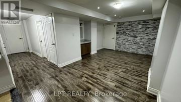 Brampton (Bram East) apartment for rent - A room with a stone wall and wooden flooring.