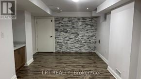 Brampton (Bram East) apartment for rent - A room with a stone wall and wooden flooring.
