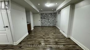 Brampton (Bram East) apartment for rent - A room with a stone wall and wooden flooring.