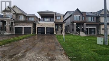 Clarington (Courtice) apartment for rent - A row of houses with a sign that says RE/MAX Community Realty Inc. Brokerage.