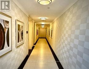 Toronto (Etobicoke West Mall) condo for rent - A hallway with a checkered floor and walls, and pictures on the wall.