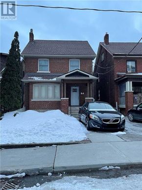 Toronto (Corso Italia-Davenport) apartment for rent - A black car is parked in front of a house with a snow bank.