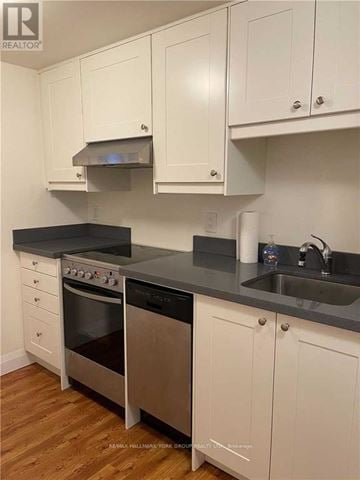 Toronto (Corso Italia-Davenport) apartment for rent - A kitchen with white cabinets and a black countertop.