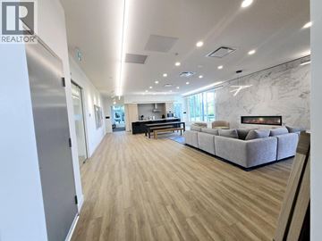 Coquitlam apartment for rent - A spacious living room with a grey sofa and wooden flooring.
