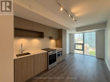 Toronto (Church-Yonge Corridor) condo for rent - A modern kitchen with wooden cabinets and stainless steel appliances.