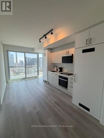 Toronto (Kensington-Chinatown) house for rent - A modern kitchen with white cabinets and a view of the city.