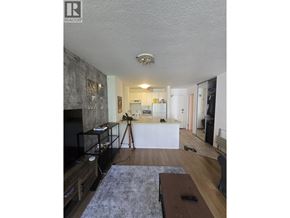 Vancouver apartment for rent - A living room with a grey rug and a black television.