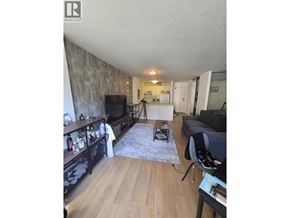 Vancouver apartment for rent - A living room with a grey couch and a wooden floor.