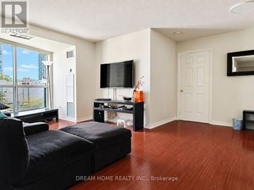 Toronto (Willowdale West) condo for rent - A living room with a black sofa and a flat screen TV.