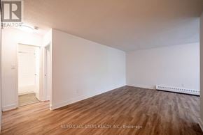 Whitchurch-Stouffville (Stouffville) multi-family for rent - A room with wooden flooring and white walls, with a doorway leading to another room.