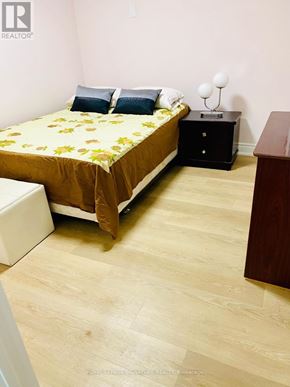 Toronto (Eglinton East) apartment for rent - A bedroom with a bed, nightstand, and chair.