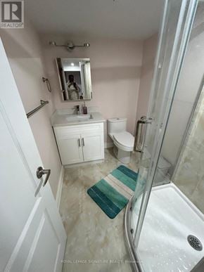 Toronto (Eglinton East) apartment for rent - A white bathroom with a glass shower stall and a white toilet.