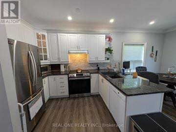 Barrie (Painswick South) apartment for rent - A modern kitchen with white cabinets and a black countertop.