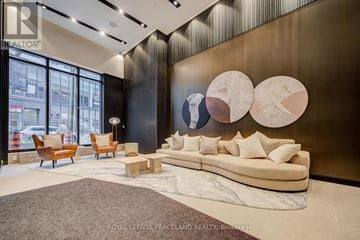 Toronto (Mount Pleasant West) condo for rent - A modern living room with a large couch and a wooden coffee table.