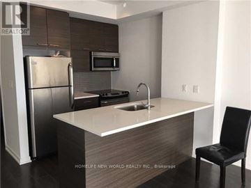 Toronto (Henry Farm) condo for rent - A modern kitchen with a refrigerator, microwave, oven, sink, and a black chair.