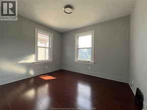 Windsor apartment for rent - A room with a wooden floor and two windows.