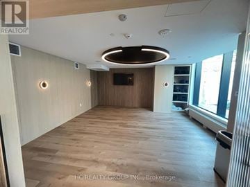 Mississauga (Mississauga Valleys) condo for rent - A spacious room with wooden flooring and a large window on the right side.