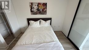 Toronto (Trinity-Bellwoods) condo for rent - A bedroom with a white bed and a framed picture on the wall.
