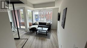 Toronto (Trinity-Bellwoods) condo for rent - A living room with a couch and a chair.