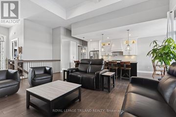 Middlesex Centre (Komoka) apartment for rent - A modern living room with black leather furniture and a wooden coffee table.