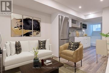 Toronto (Playter Estates-Danforth) duplex for rent - A modern living room with a white couch, a brown armchair, and a painting on the wall.