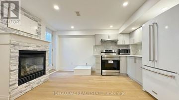 Mississauga (Churchill Meadows) apartment for rent - A modern kitchen with white cabinets and a stone fireplace.