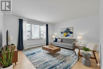 Ottawa triplex for rent - A living room with a grey couch, a coffee table, and a painting on the wall.