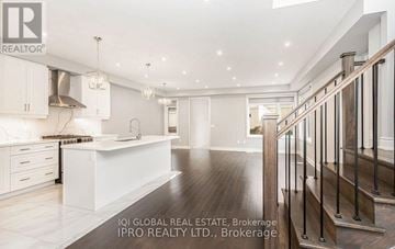 Brampton (Northwest Brampton) apartment for rent - A spacious kitchen with white cabinets and a wooden staircase.