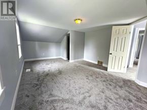 Wellington North (Mount Forest) multi-family for rent - A spacious room with a carpeted floor and a white door.
