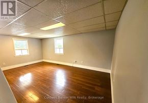 Wellington North (Mount Forest) multi-family for rent - A room with wooden flooring and two windows.