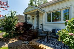 St. Catharines (Downtown) apartment for rent - A small house with a porch and a table and chairs on it.
