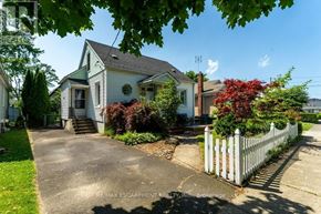 St. Catharines (Downtown) apartment for rent - A white picket fence surrounds a house with a driveway leading to the front door.