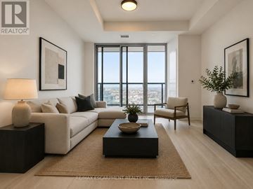 Burlington (Alton) condo for rent - A modern living room with a large window overlooking the city.
