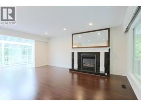 West Vancouver apartment for rent - A large, empty room with a fireplace and a large mirror above it.