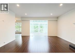 West Vancouver apartment for rent - A large empty room with wooden floors and a sliding glass door.