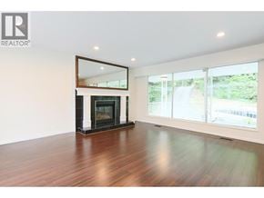 West Vancouver apartment for rent - A large, empty room with a fireplace and a mirror above it.