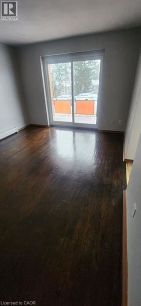 Kitchener apartment for rent - A room with wooden floors and a large window.
