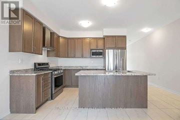 Thorold (Rolling Meadows) apartment for rent - A kitchen with a stove top oven, microwave, and refrigerator.