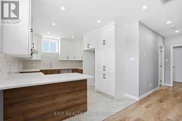 Hawkesbury apartment for rent - A kitchen with white cabinets and a wooden counter.