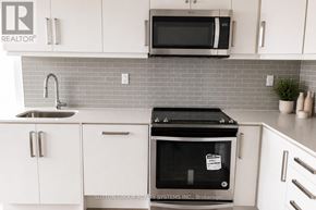 Toronto (Willowdale West) condo for rent - A kitchen with white cabinets and a grey backsplash.