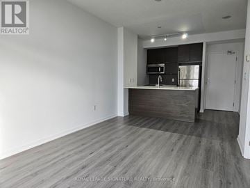 Toronto (Henry Farm) condo for rent - A spacious room with a kitchenette in the background.