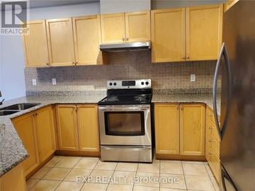 Oakville (Ga Glen Abbey) townhouse for rent - A kitchen with wooden cabinets and a stainless steel refrigerator.
