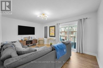 Milton (Tm Timberlea) townhouse for rent - A living room with a grey couch and a flat screen TV mounted on the wall.