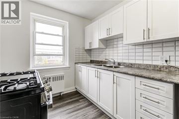 Hamilton apartment for rent - A kitchen with white cabinets and a black stove top.