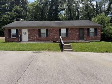 Lanesville apartment for rent - A small brick house with a white door and black windows.