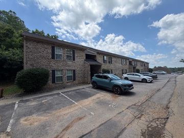 Sellersburg apartment for rent - A parking lot with cars and a building in the background.