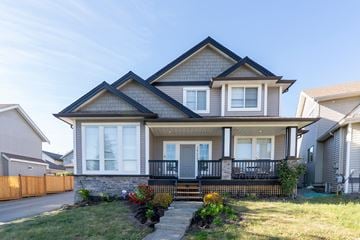 Surrey apartment for rent - A house with a grey roof and white walls has a black railing on the balcony.