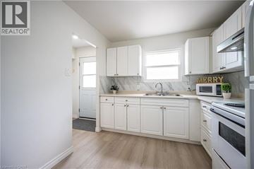 Waterloo townhouse for rent - A kitchen with white cabinets and a wooden floor.