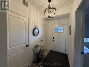 Blue Mountains condo for rent - A hallway with a white door, a mirror, and a light fixture.