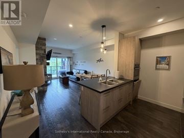 Blue Mountains condo for rent - A modern kitchen with wooden cabinets and a stone wall.